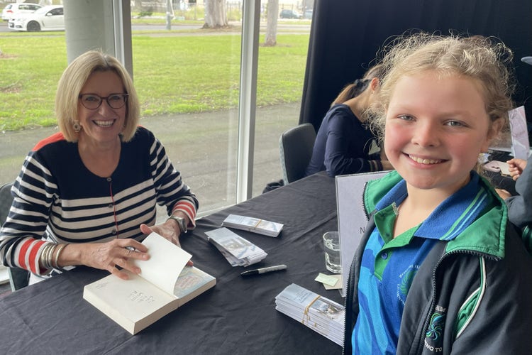Student with author signing book at the festival