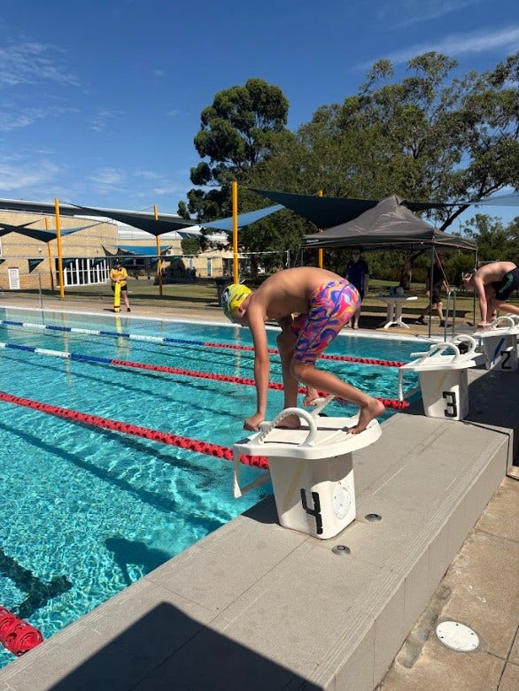 Student getting ready to dive off a diving board into the pool